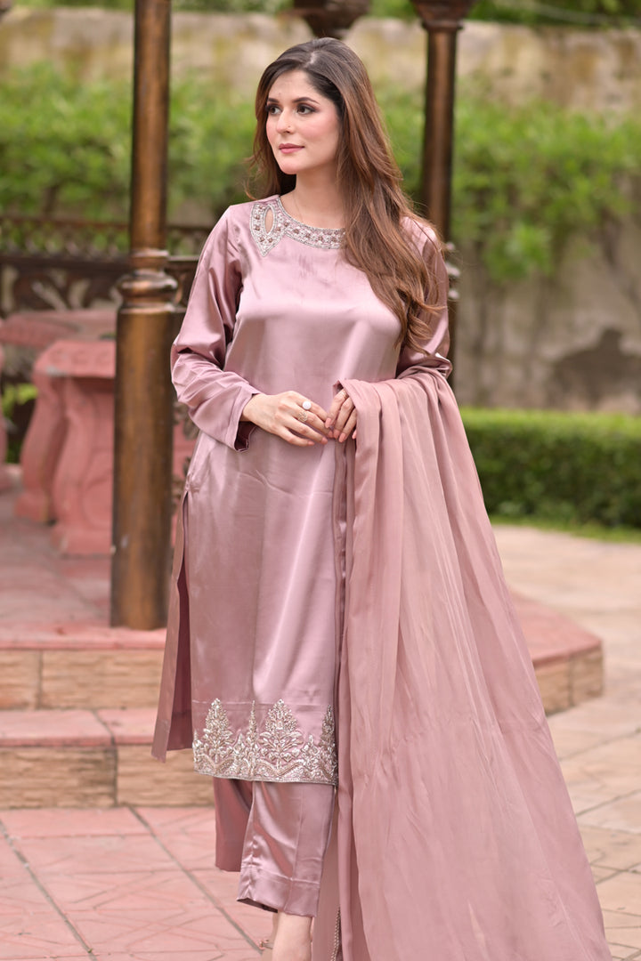Woman wearing a pink traditional outfit with embroidery in an outdoor setting