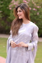 Woman in a light purple traditional outfit with floral background