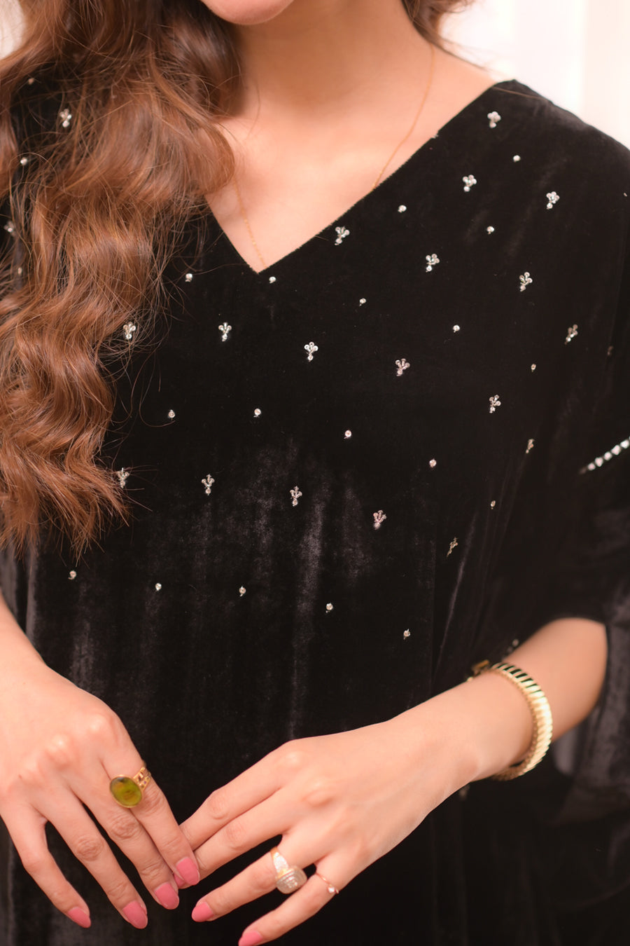 Black velvet dress with silver embellishments worn by a person.