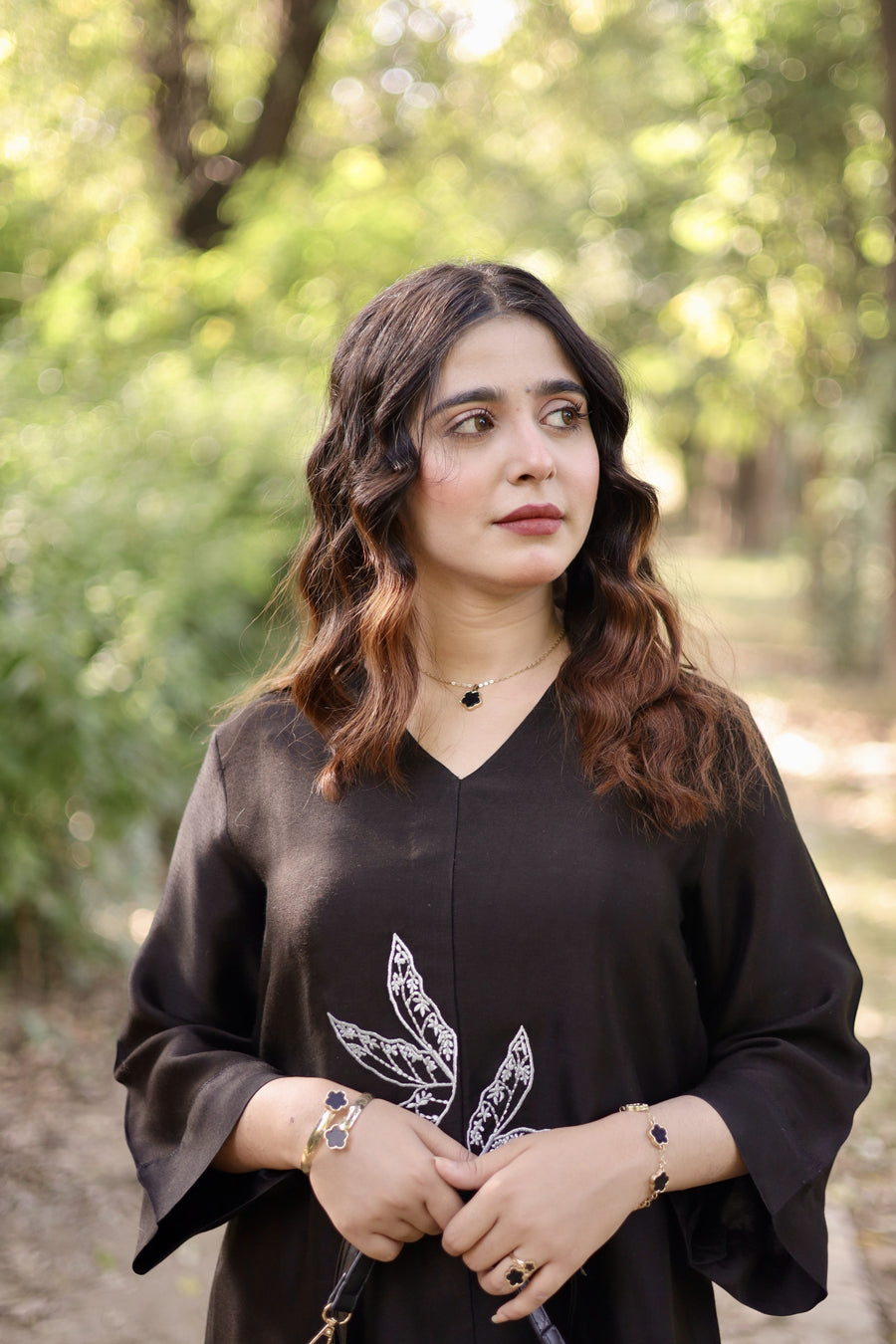 Woman wearing a black outfit with a white design in an outdoor setting