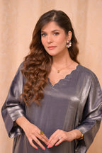 Woman wearing a gray metallic dress with a beige background