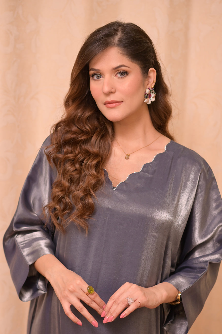 Woman wearing a gray metallic dress with a beige background